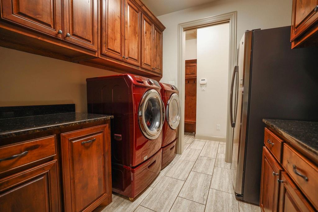 1387 Shadow Lakes Drive Wills Point, TX 75169 - Photo 12 of 30 Washroom featuring cabinet space, wood tiled floors, washer and clothes dryer, and baseboards