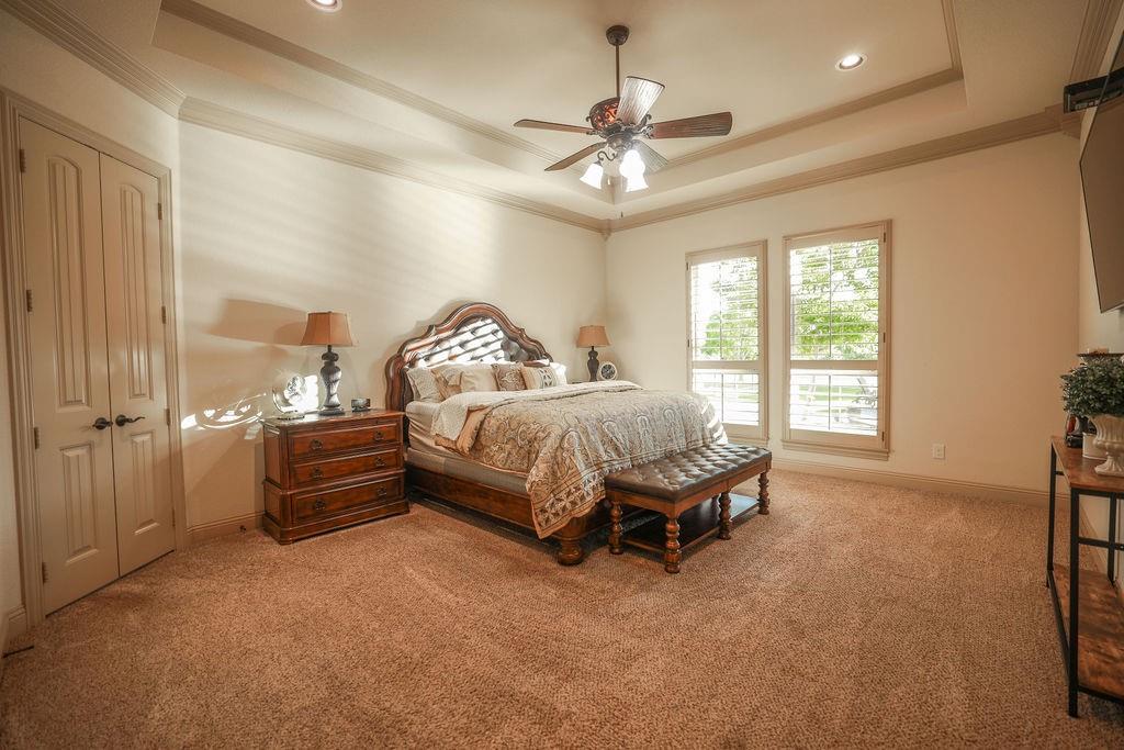 1387 Shadow Lakes Drive Wills Point, TX 75169 - Photo 13 of 30 Primary bedroom with a tray ceiling, ornamental molding, baseboards, and ceiling fan