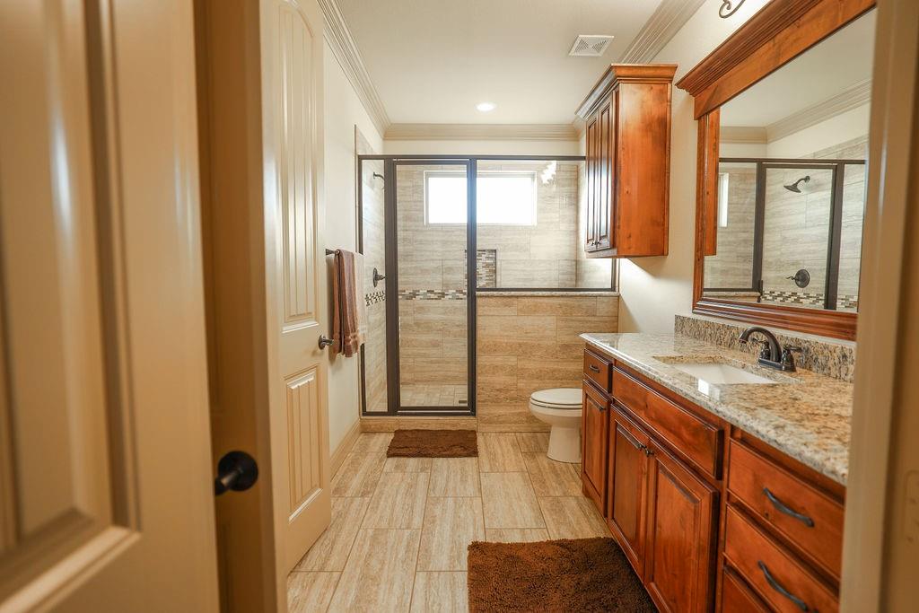 1387 Shadow Lakes Drive Wills Point, TX 75169 - Photo 17 of 30 2nd primary Bathroom featuring toilet, crown molding, a stall shower, and vanity