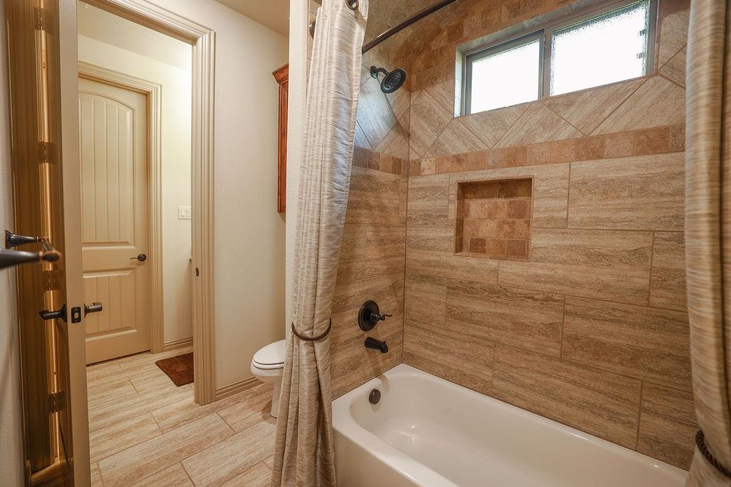 1387 Shadow Lakes Drive Wills Point, TX 75169 - Photo 19 of 30 Full Jack and Jill bath with shower / bath combo with shower curtain, toilet, and tile patterned floors
