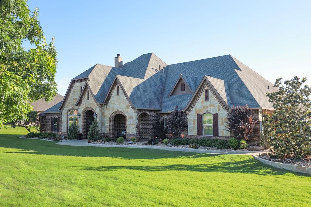1387 Shadow Lakes Drive Wills Point, TX 75169 - Photo 3 of 30 View of front of house with stone siding, a front lawn, and a chimney