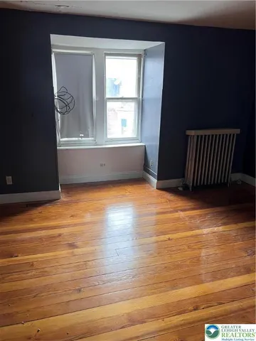 a view of a room with wooden floor and a window