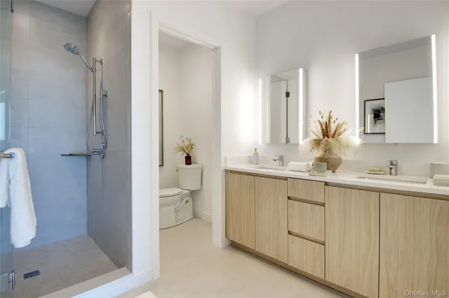a bathroom with a granite countertop sink mirror and toilet