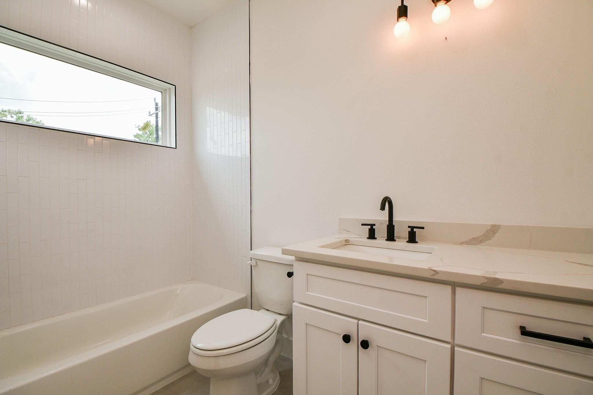 2305 Maury Street Houston, TX 77026 - Photo 15 of 19 a bathroom with a sink a toilet and a bathtub