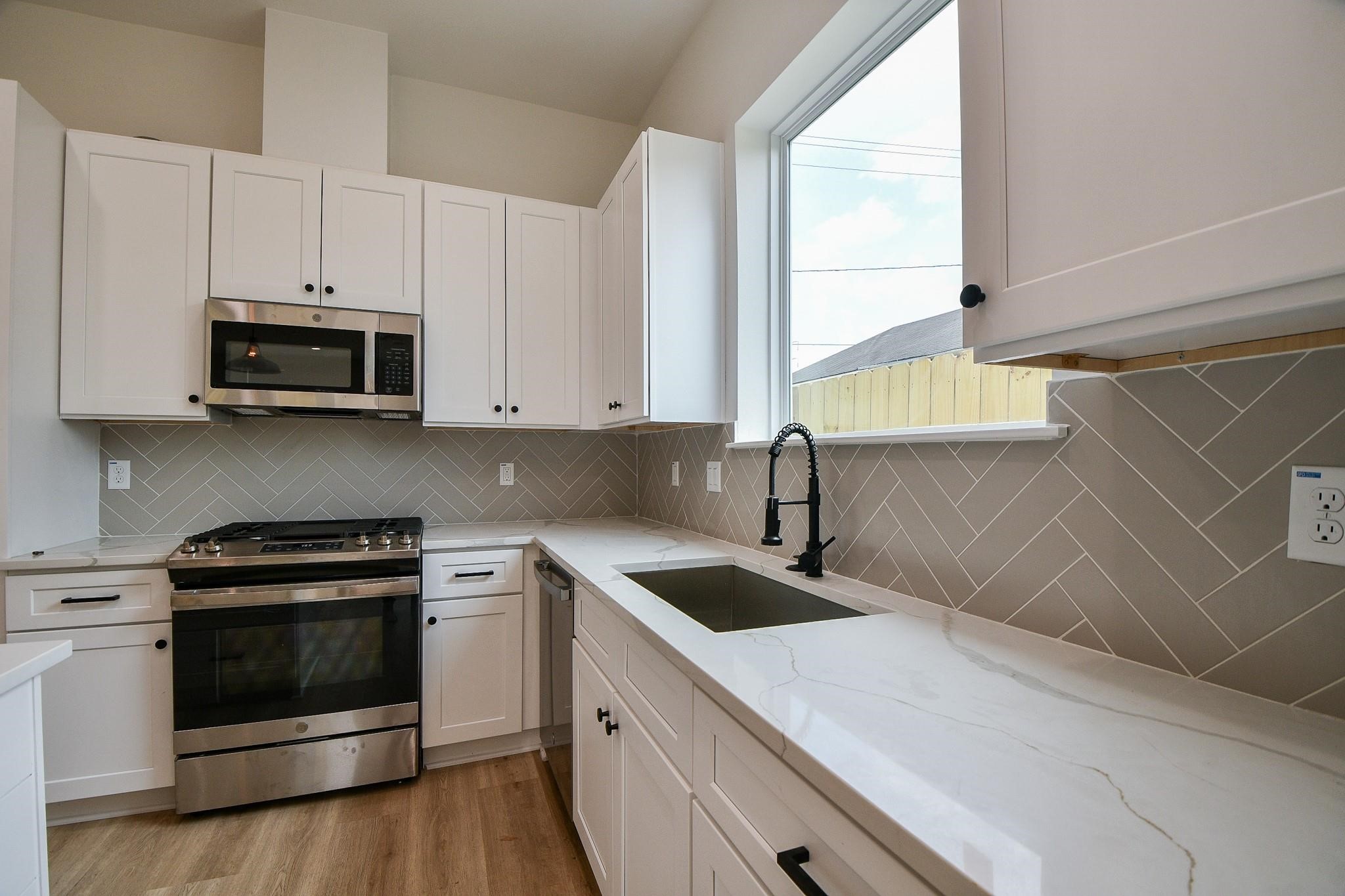 2305 Maury Street Houston, TX 77026 - Photo 3 of 19 a kitchen with granite countertop white cabinets and white appliances