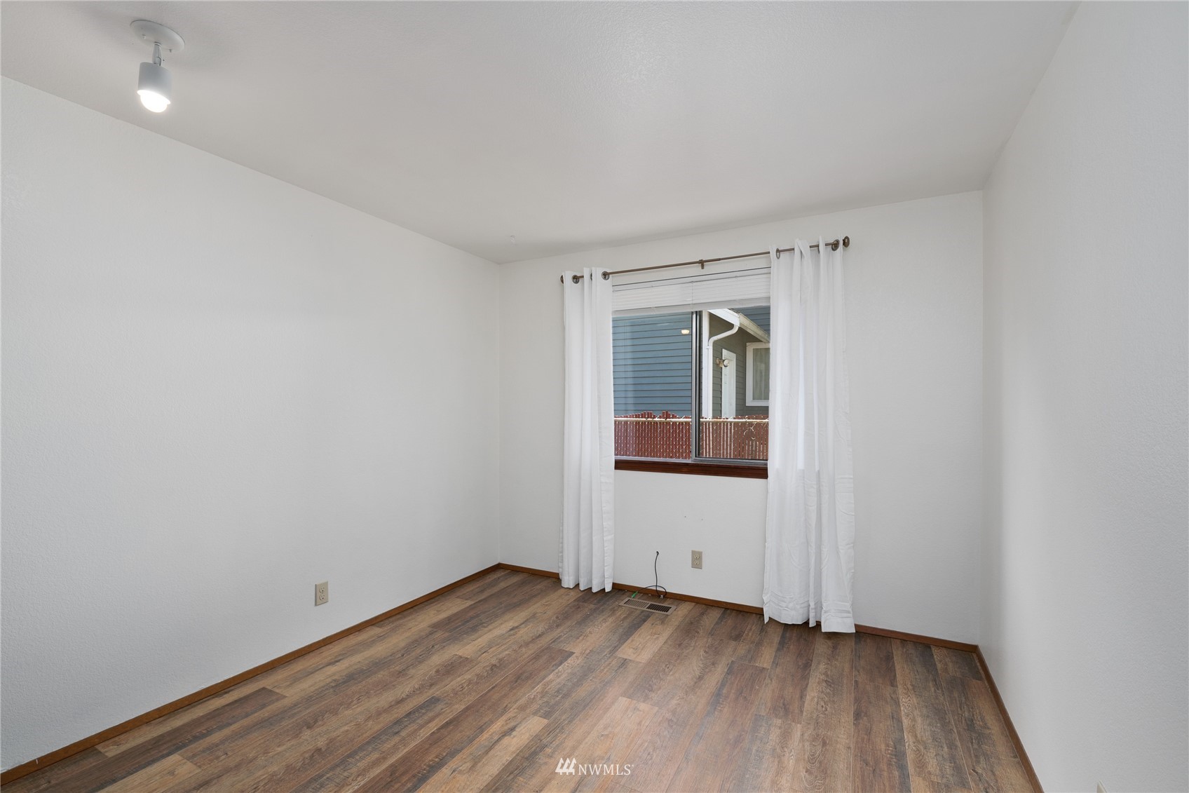813 226th Street Southeast Bothell, WA 98021 - Photo 16 of 30 a view of an empty room with wooden floor and a window