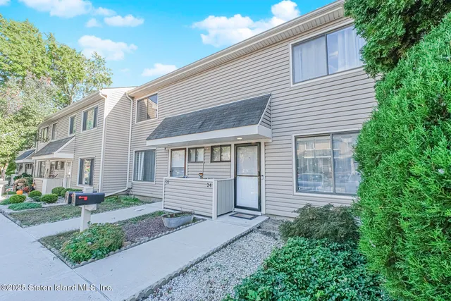a front view of a house with a garden