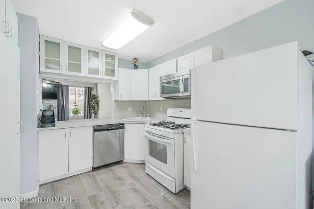 a kitchen with white cabinets and white appliances