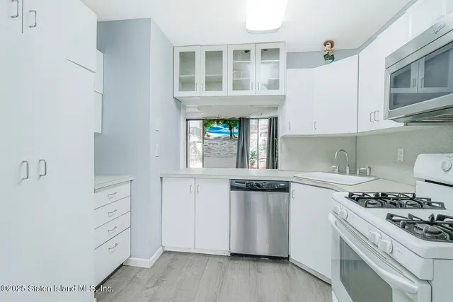 a kitchen with white cabinets and appliances