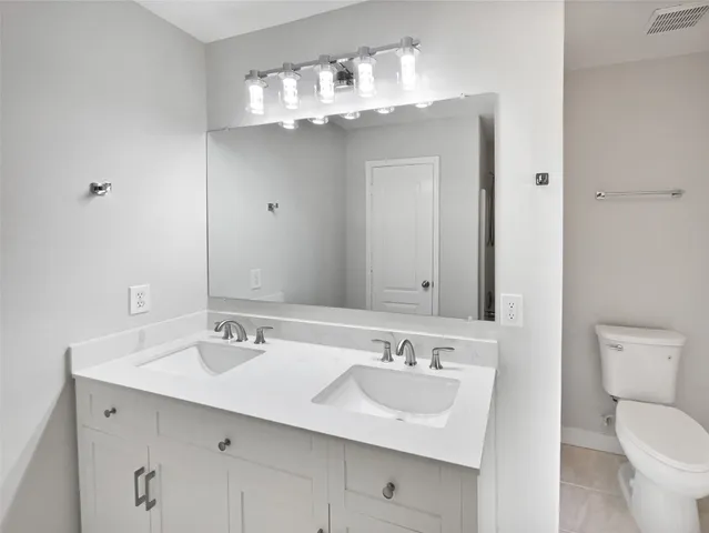 a bathroom with a toilet a sink and mirror
