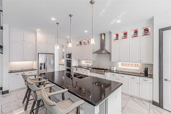 a kitchen with stainless steel appliances granite countertop a kitchen island a stove and a refrigerator