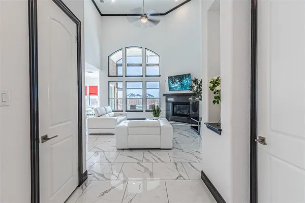 a living room with furniture a fireplace and a floor to ceiling window