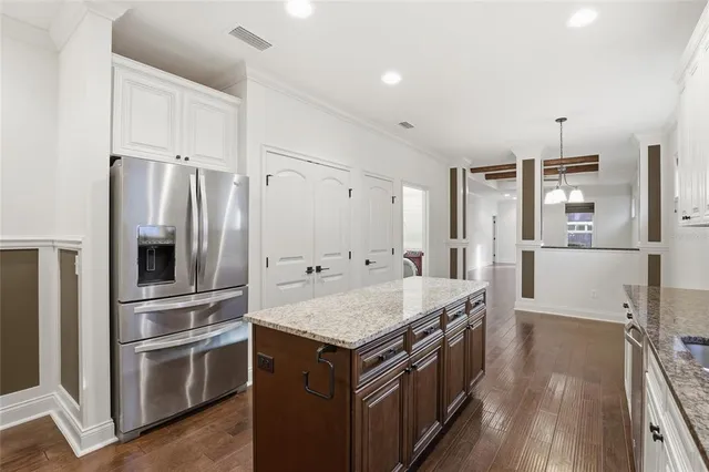 a large kitchen with stainless steel appliances and white cabinets