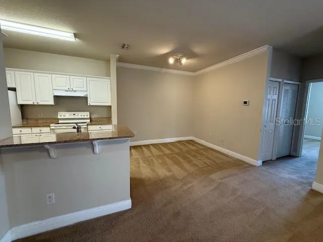 a view of kitchen with stainless steel appliances refrigerator oven and cabinets
