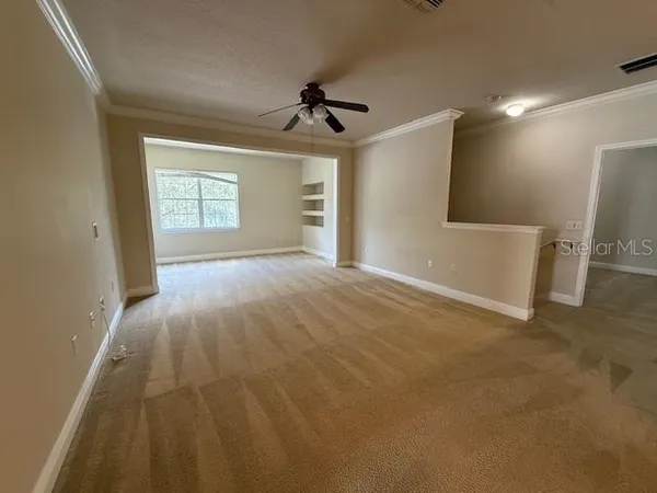 en empty room with windows and ceiling fan