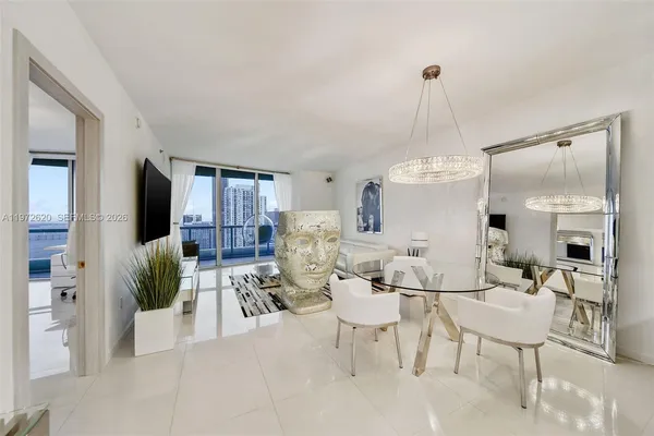 a living room with furniture dining table and a chandelier