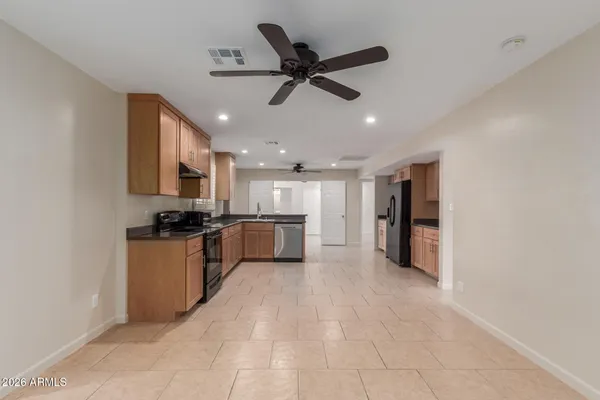 a open kitchen with stainless steel appliances kitchen island granite countertop a refrigerator a sink a stove and oven with wooden floor