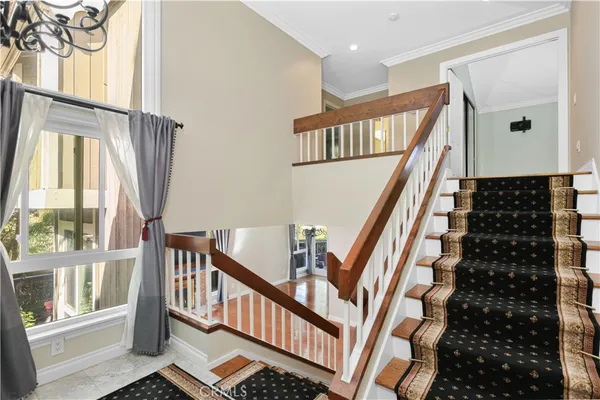 a view of staircase with lots of frames on wall and a window