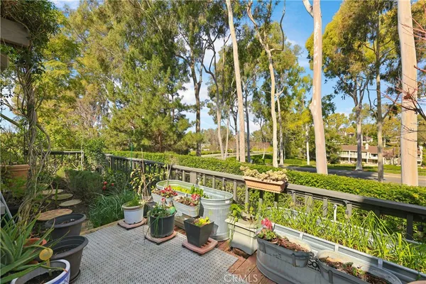 a view of a balcony with chairs and wooden fence