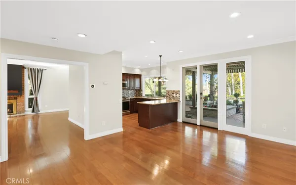 a view of a kitchen with refrigerator and wooden floor