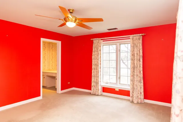 a view of empty room with window and ceiling fan