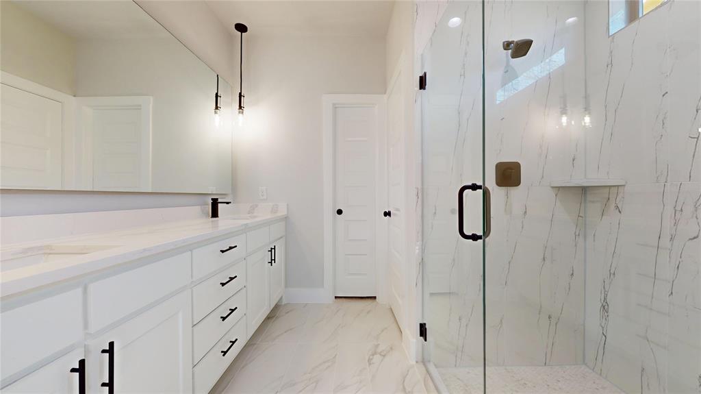 801 Birch Street Grand Prairie, TX 75050 - Photo 15 of 28 a bathroom with a double vanity sink a shower and a mirror