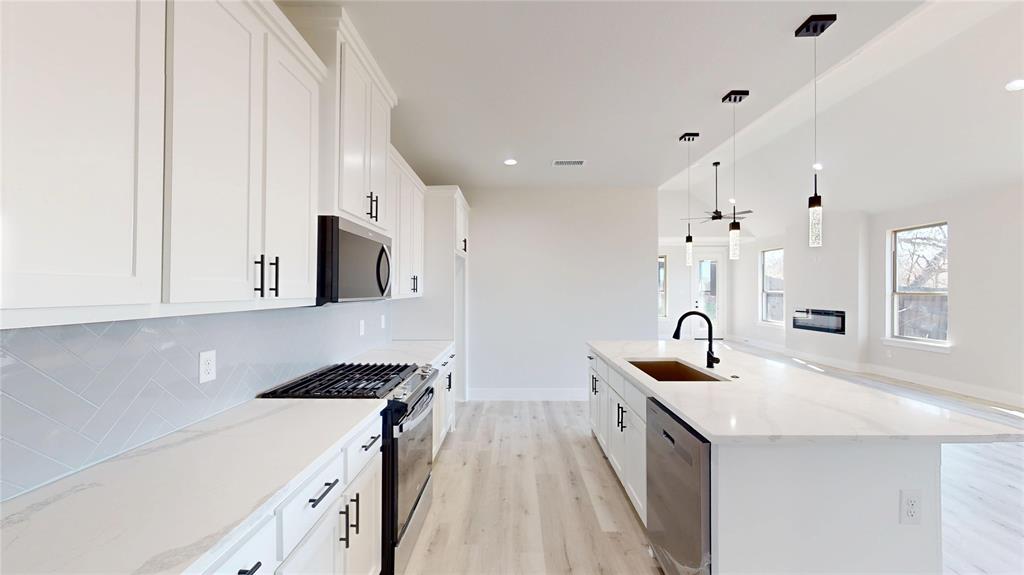801 Birch Street Grand Prairie, TX 75050 - Photo 5 of 28 a kitchen with stainless steel appliances granite countertop a sink stove and cabinets