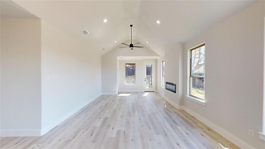 801 Birch Street Grand Prairie, TX 75050 - Photo 8 of 28 a view of an empty room with window and wooden floor
