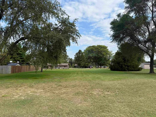 a view of a field of grass and trees