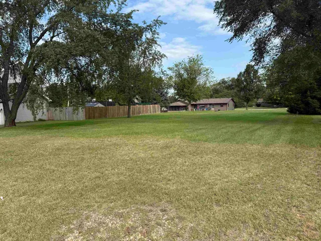 a view of a field of grass and trees