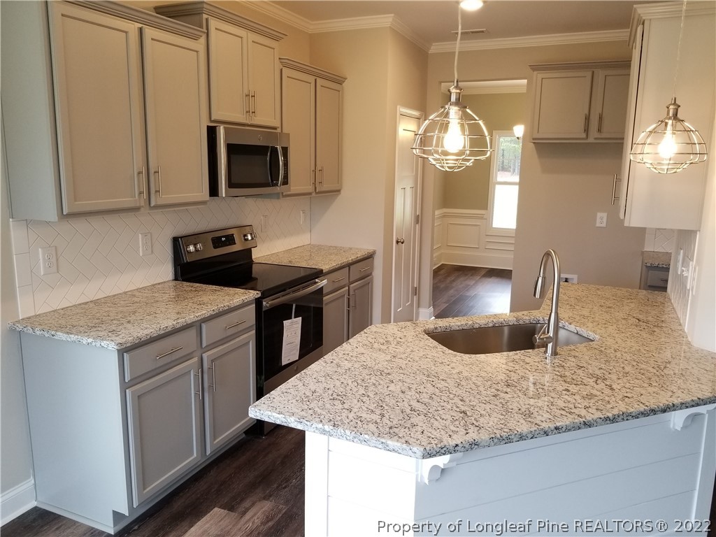 5224-lot7 J T Matthews Road Godwin, NC 28344 - Photo 14 of 42 a kitchen with stainless steel appliances granite countertop a sink a microwave counter space and cabinets