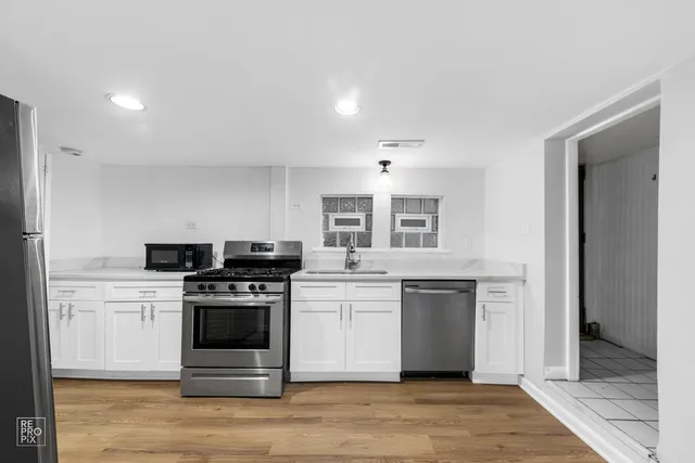 a kitchen with a stove top oven and cabinets