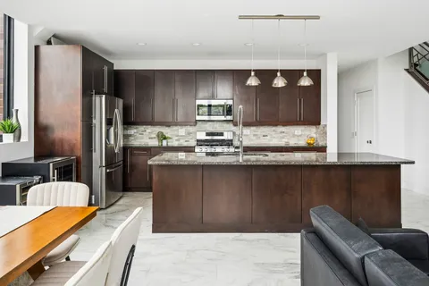 a kitchen with stainless steel appliances granite countertop a refrigerator and a sink