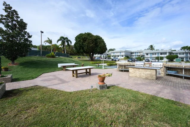 a swimming pool with outdoor seating and a garden