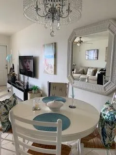 a dining room with wooden floor a chandelier a wooden table and chairs