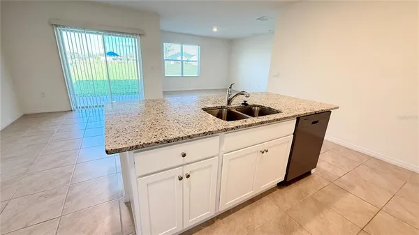 a kitchen with white cabinets a sink and dishwasher