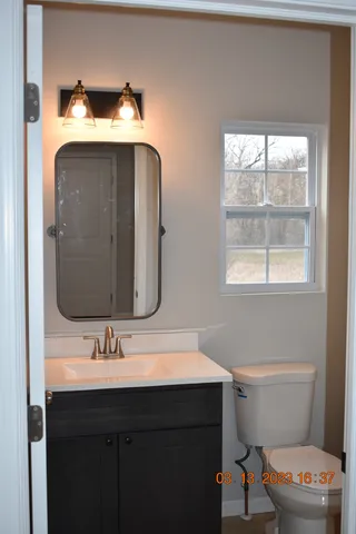 a bathroom with a toilet sink and mirror