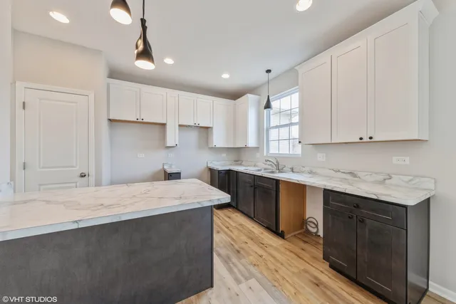 a kitchen with stainless steel appliances granite countertop a sink dishwasher a stove and a refrigerator with wooden floor