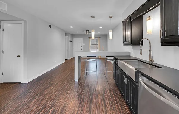 a large kitchen with stainless steel appliances granite countertop a lot of counter space and wooden floor