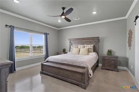 a bedroom with a large bed and a chandelier