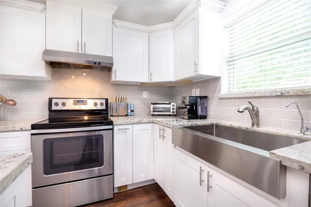 a kitchen with granite countertop white cabinets stainless steel appliances and sink