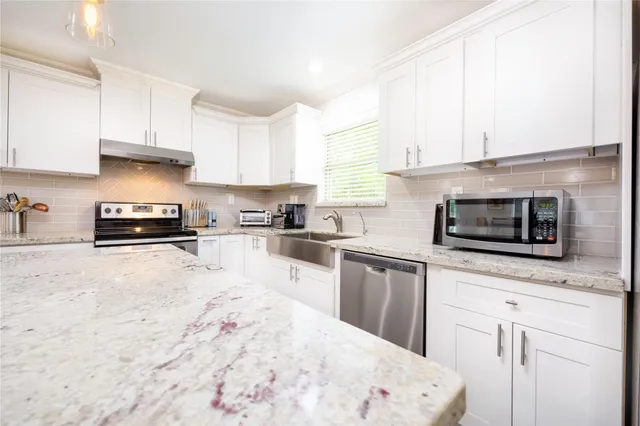 a kitchen with stainless steel appliances kitchen island granite countertop a stove a sink and a microwave