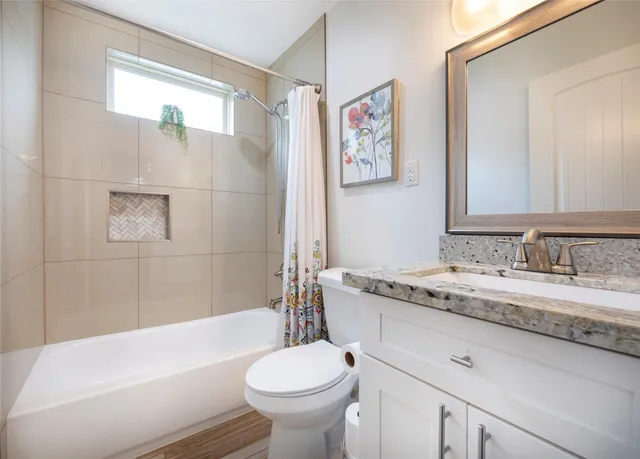 a bathroom with a granite countertop sink toilet and bathtub