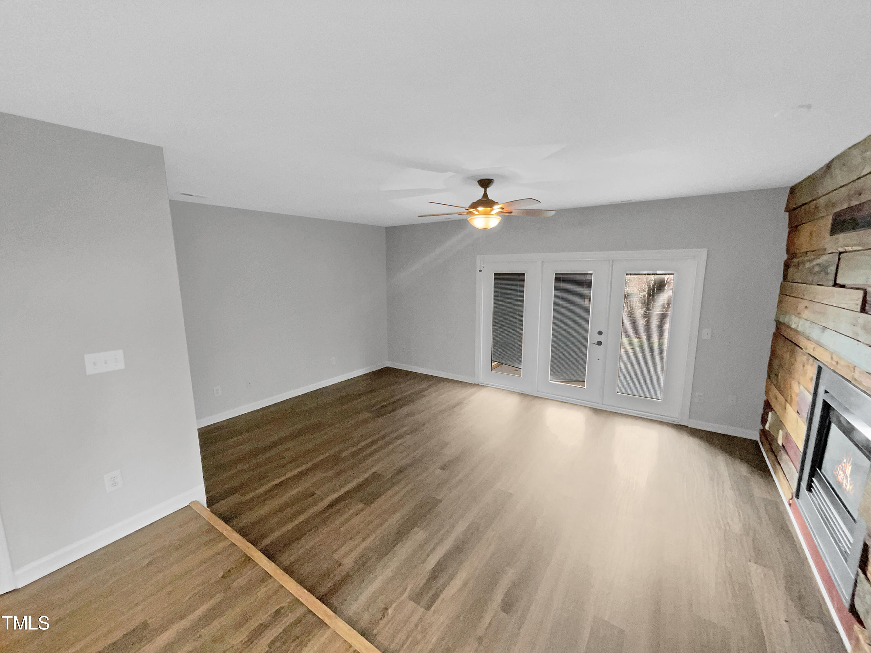 4227 Sunscape Lane Raleigh, NC 27613 - Photo 3 of 18 a view of an empty room with wooden floor and a fireplace