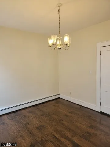 a view of a room with wooden floor and chandelier