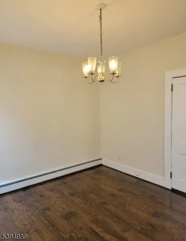 a view of a room with wooden floor and chandelier
