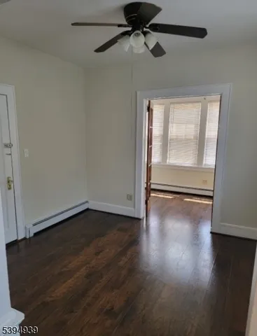 a view of a livingroom with wooden floor a ceiling fan