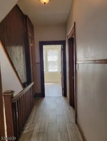 a view of a hallway with wooden floor and staircase