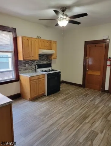 a living room with stainless steel appliances granite countertop furniture a fireplace and wooden floor