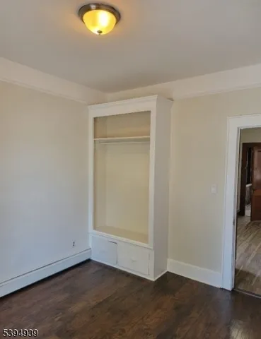 an empty room with wooden floor and closet